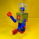 Colorful toy wooden robot with a floral design on the chest and a clear helmet. A tiny cat head is inside the helmet.