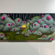 Illustration of a dark forest with many rocks, all with frowning faces and large pink shiny eyes. In the center sits a girl in a green hood and tights. Behind her is a crate holding glowing golden objects.