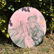 Softly rendered graphite drawing on pink panel of a person with a large jacket, baseball cat and a tote bag over their shoulders. They face away from the viewer, only a peek of their face can be seen. In their tote is a large bouquet of mum flowers, as well as a branch with a single starfruit on it. Pencil has a subtle green tint and background is a pastel pink.
