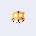 3D ceramic brooch/pin of a tiger's head, with small eyes, a cute smile and striping on its face.