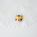 3D ceramic brooch/pin of a tiger's head, with small eyes, a cute smile and striping on its face.