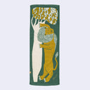 Long green tea towel with an artistic illustration of a lion (or tiger) stretched out next to a Saharan tree.