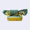 Green and yellow fabric tenugui folded as though wrapping a present.