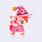 "Lovecraft" unicorn figure, mostly pink with a red mane and tail. It is dressed like a pink witch, with a hat and cloak, decorated with hearts with bat wings and stars. On its back is a clear flask with hearts inside.