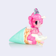 Pink semi transparent unicorn figure with pink strawberry mane wrapped inside of a strawberry crepe.