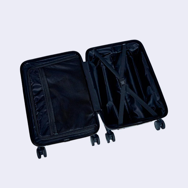 Interior of a hard cased carry on luggage suitcase, totally black with a satin lining and zipper compartments.