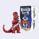 Red dinosaur-like toy holding a gun next to a robot toy with packaging in the background