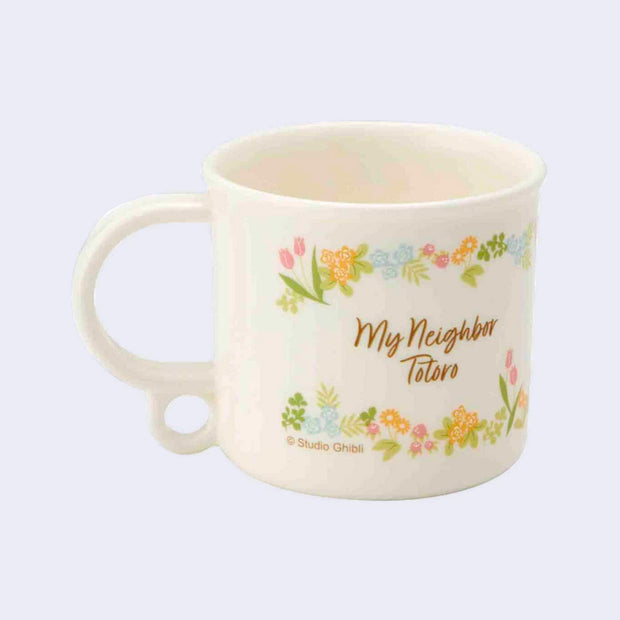 Back view of a short white plastic cup with a mug handle, featuring a vintage floral pattern framing of "My Neighbor Totoro" written in cursive.
