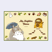 Graphic used for mat design, yellow background with a green outline featuring an illustration of Totoro playing a small wind instrument and holding an umbrella. Next to him, Catbus scurries away leaving paw prints. "My Neighbor Totoro" is written in the middle.