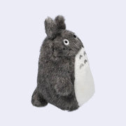 Dark gray Totoro plush, with a large white furry belly and whiskers. View from the side.
