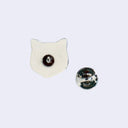 Back view of a ceramic pin shaped like a cat's head with a metal pin and matching backing.
