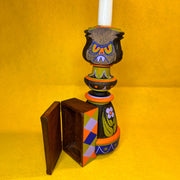 Decorative candle holder with geometric design on a yellow background