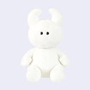 White plush toy with black eyes and soft curved horns.