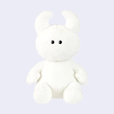 White plush toy with black eyes and soft curved horns.
