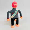 Toy figure with red head and gray shirt on a light gray background