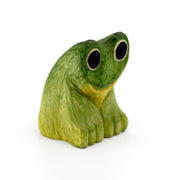 Small whittled wooden sculpture of a green frog with very large eyes, mostly large black circles with a thin yellow outline.