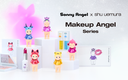 A promotional display for the Sonny Angel x shu uemura Makeup Angel Series, featuring small character figurines, lipstick tubes, and cosmetic palettes arranged on white pedestals against a soft pink and white background.