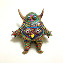 Colorful monster figurine with geometric patterns on a white background