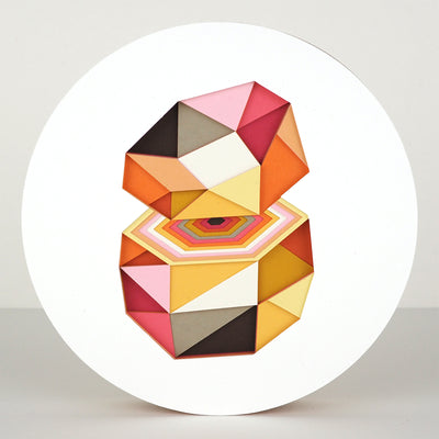 Geometric designed layered cut paper sculpture, creating a three dimensionality. A 10 sided shape is cut horizontally, revealing a hexagonal interior. Colors are orange, brown, yellow, pink and white.