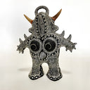 Black and white figurine with intricate patterns and brown horns on a white background
