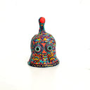 Colorful clay sculpture shaped like a bell with abstract design on a white background