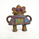 Colorful clay figure made to look like a toy robot of sorts, covered in very intricate design patterns with 2 eyes in the center.