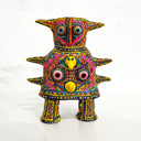 Colorful clay figure made to look like a toy robot of sorts, covered in very intricate design patterns with 2 eyes in the center.