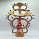 A ceramic sculpture stylized as a Mexican Tree of Life, with a brown glazed trunk and branches, decorated with a yellow crescent moon, a white rabbit, a yellow sun, and a red fox, set against a plain light gray background.