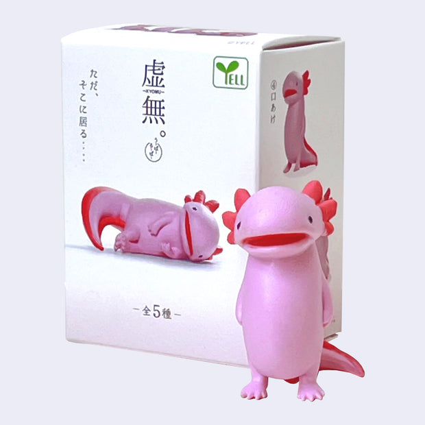 Pink axolotl figurine in front of a white box with axolotl illustrations. It stands with its mouth ajar, like it is zoning out.