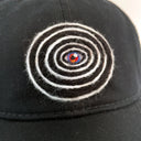 Black cap with a colorful spiral design on a white background