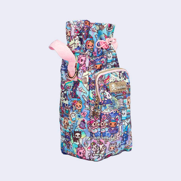 Tall rectangular shaped bag, made for fitting a reusable water bottle inside. Bag features pastel pink colored fabric detailing, around the zipper and as the handles/straps. Bag has a small "tokidoki" nameplate on the center and is covered completely in a busy colorful pattern featuring tokidoki characters with with galactic and sci fi imagery.