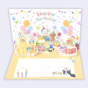 A 3D pop-up dog birthday card with a colorful illustration of dogs, gifts, balloons, and the text 'Happy Birthday' on the back panel, shown open with a blank writing area on the front.