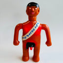 Vintage toy figure with a sash on a white background