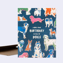 Greeting card, a navy blue with illustrations of many cololrful dogs, standing or sitting in relaxed manners with text in the center that reads "I Hope Your Birthday is Full of Dogs".