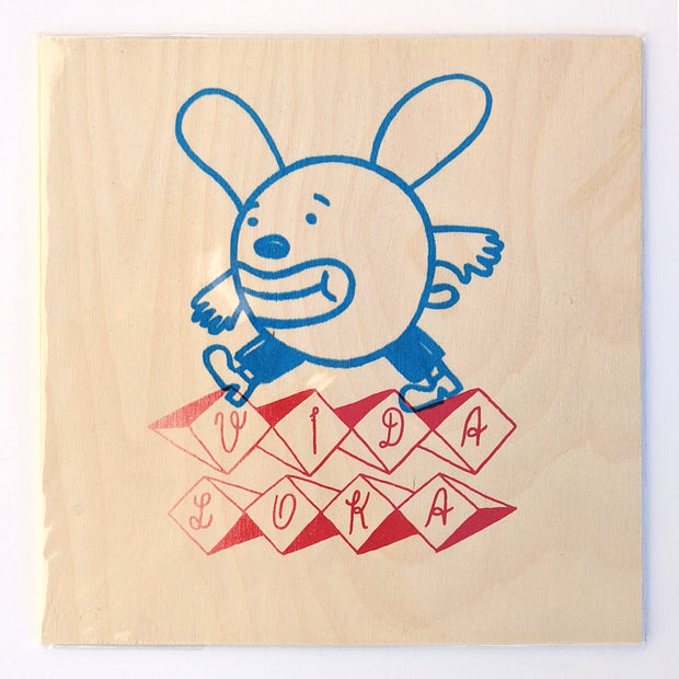 Red and blue ink screenprint on wood, of a cartoon style bunny with a round head and pants stepping on stylized text that reads "Vida Loka."