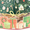 A close-up of a Christmas-themed pop-up card or decorative paper artwork showing wrapped gift boxes, ornaments, candy canes, a small house, snowflakes, and a gold ribbon bow against a dark green patterned background.
