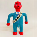 Toy figure with red face and blue suit on a beige background