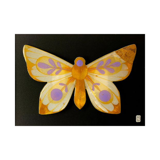 Painting on cut out paper of a butterfly with orange, yellow and purple coloring. Its wings are mostly tipped with orange glitter and have purple circle and leave patterns on the rest of the wing. Butterfly is gold outlined and mounted on black paper.
