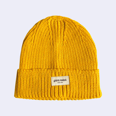 Knit beanie in a bright goldenrod color, with a small rectangle patch on the front that says "giant robot" and "since 1994" below in all caps.