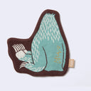 Die cut fabric coaster, shaped to the design of a seated blue snow yeti, with large feet that are slightly lifted up. Border is brown. Backside of coaster, which is also the back view of the design.