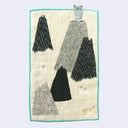 Rectangular cream colored towel with a bright blue border with illustrations of mountains and a blue snow yeti, standing atop of one with its arms up.
