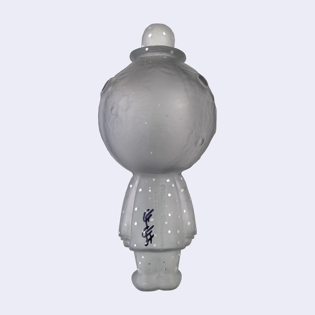 Translucent gray sculpture of a cratered moon with a simplistic, closed eye smiling face. It wears a bowler hat and a suit, arms at its side, with painted silver dots on the hat and suit. Sculpture is reminiscent of Magritte. Signed by Yoskay Yamamoto on the back.