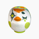 Painted Daruma shaped figure make to look like a white owl with green and orange color accents.