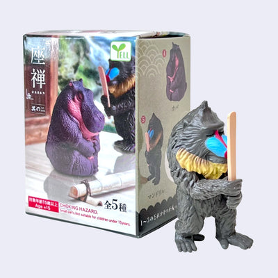 Figurine of a baboon, standing on 2 legs like a person with closed eyes and a stick in front of its face.
