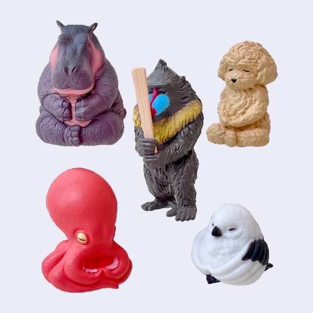 5 animal figurines, sitting in meditative poses - animals are: hippo, dog, octopus, bird and baboon.