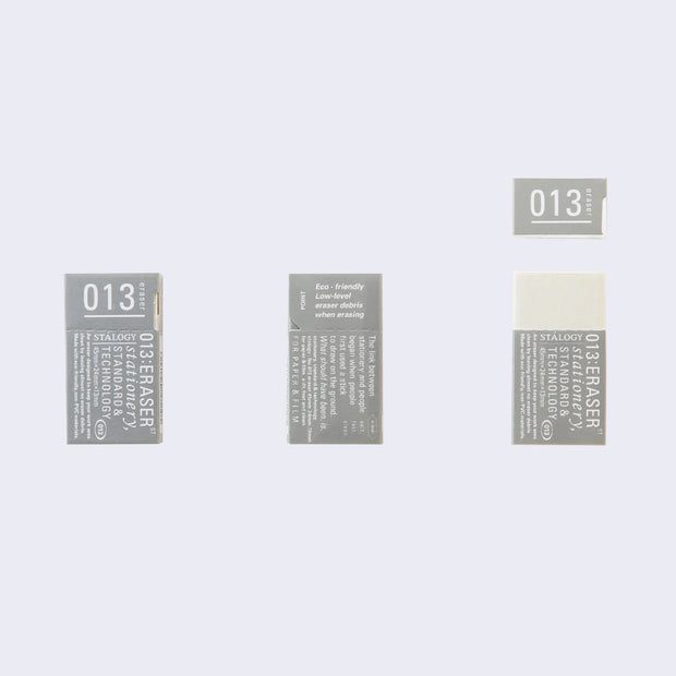 3 small rectangle shaped gray cardboard packaging. One shows front of package, one shows back and the last shows a white rubber eraser within the packaging.