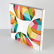 White paper with 4 colorful geometric shapes on each side of the sheet, made up of layers of colorful paper assembled into a larger geometric shape. Shown at the side to display 3 dimensionality