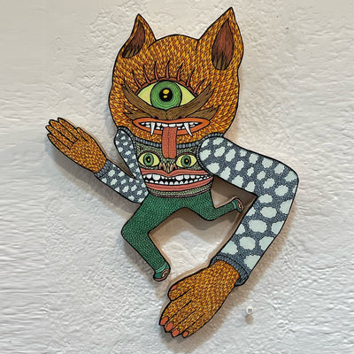 Illustrated wood cut figure of a furry cyclops with a mustache, in stride as if mid sprint. Its arms are larger than its legs, creating a perspective of it coming forward. It wears a sweater vest with a monster on it over long sleeve with a cloud pattern .