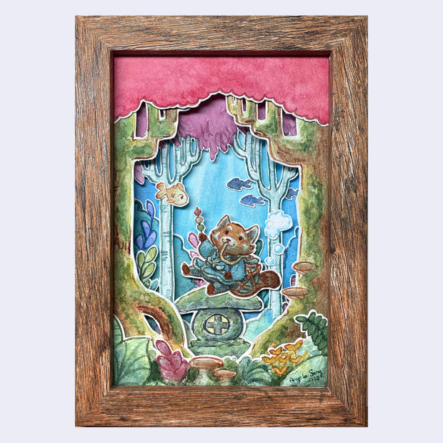 Layered watercolored paper in a wooden frame, akin to a shallow shadow box. A cartoon red panda sits on a stone shrine eating dango and breathing with a pouch on its back. It's underwater and also in a forest of sorts, with trees and greenery.