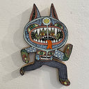 Illustrated wood cut of a series of monster heads within one another, positioned on a body wearing a sweater fest with a monster on it.